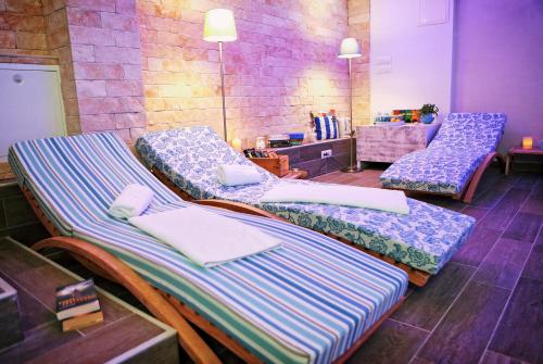 a room with three beds sitting next to a brick wall at Hotel Delfin in Zadar
