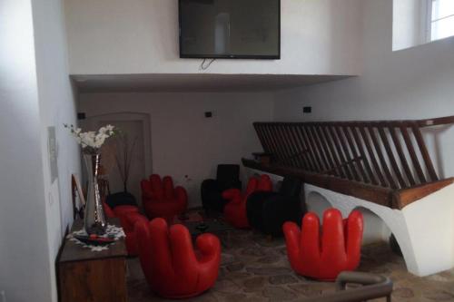 a living room with red chairs and a flat screen tv at Tapada da Eira e Chanca in Fortios