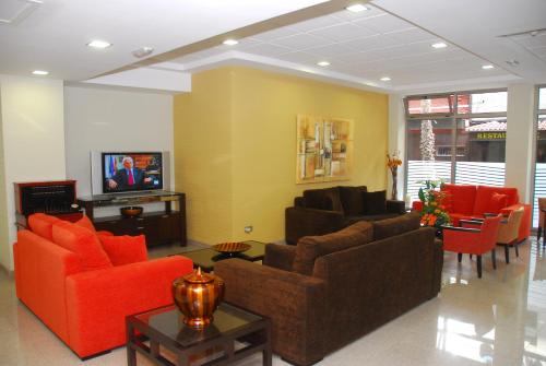ein Wohnzimmer mit Sofas und einem Flachbildfernseher in der Unterkunft Hotel Pujol in Las Palmas de Gran Canaria