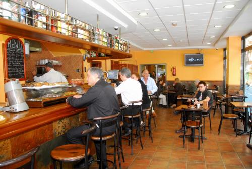 eine Gruppe von Menschen sitzt an einer Theke in einem Restaurant in der Unterkunft Hotel Pujol in Las Palmas de Gran Canaria