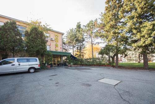 a van parked in a parking lot in front of a building at Hotel Elefante Bianco in Crespellano