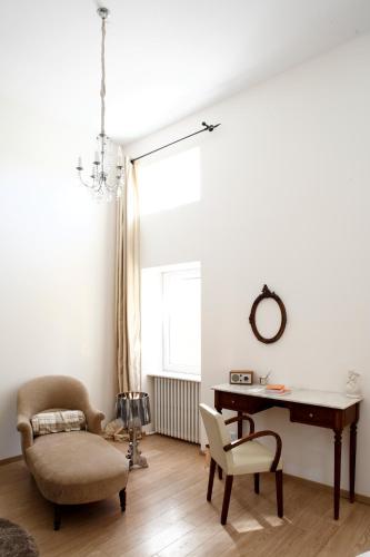 a living room with a piano and a chair and a desk at Auberge Du Paradis in Saint-Amour-Bellevue