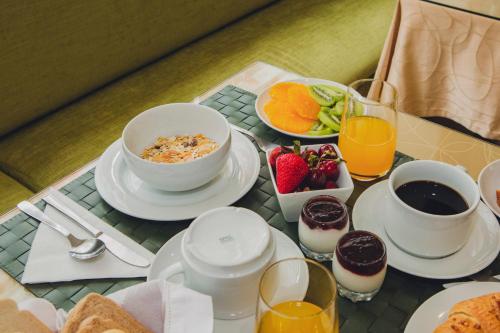 a breakfast table with a bowl of cereal and a bowl of fruit at Império do Rei Boutique Hotel in Castelo Branco