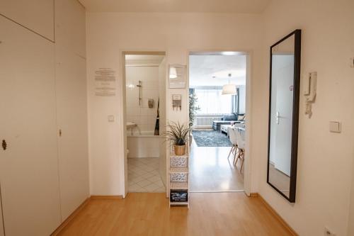 un corridoio di una casa con specchio e bagno di Downtown Apartments Unterbilk a Dusseldorf