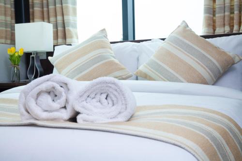 a bed with a white blanket and pillows at London City Airport Hotel in London