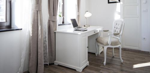 a white desk with a computer and a chair at Vila Mila in Bled