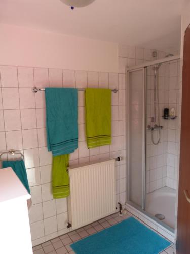 ein Badezimmer mit grünen Handtüchern und einer Dusche in der Unterkunft Oerlihome in Oerlinghausen