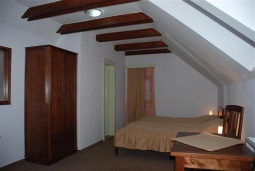 a bedroom with a bed and a dresser in a room at Borsika panzió in Ciumani