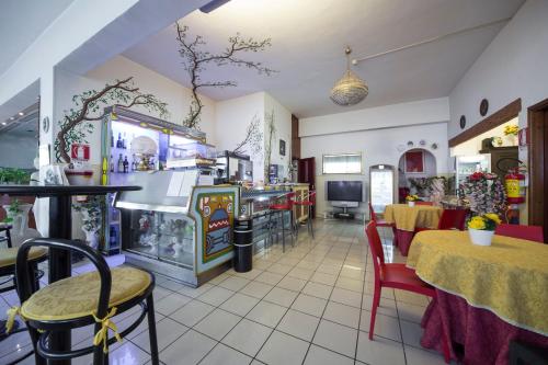 un restaurant avec un coin repas doté de tables et de chaises dans l'établissement Hotel Elefante Bianco, à Crespellano