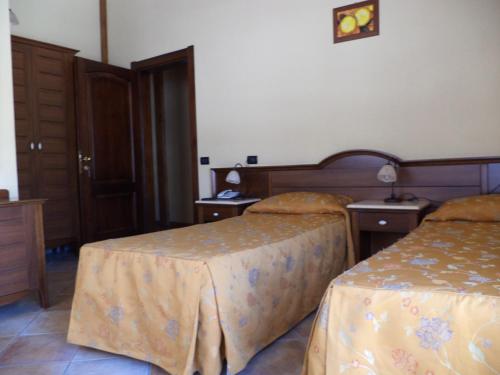 a hotel room with two beds and two tables at Hotel Cà Fiore in Bardonecchia
