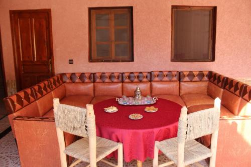 a couch with a table and chairs in a room at Dar Imperial in Imlil