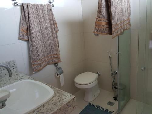 y baño con aseo, lavabo y ducha. en Maravilhosa casa de praia, en Aracaju