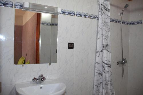 a bathroom with a sink and a mirror and a shower at Dar Imperial in Imlil