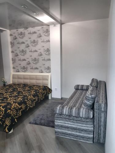 a bedroom with a bed and a couch at Стильные аппартаменты на Новых Домах in Kharkiv