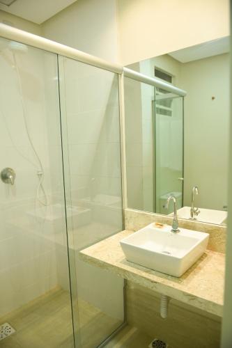 a bathroom with a sink and a glass shower at Uiramutam Palace Hotel in Boa Vista