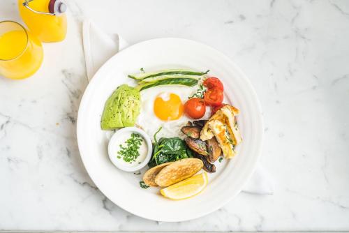 a plate of food with eggs and vegetables on a table at The Roseate Villa Bath in Bath