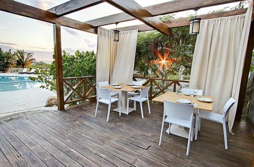 
a dining room table with chairs and umbrellas at El Morro Eco Adventure Hotel in San Fernando de Monte Cristi
