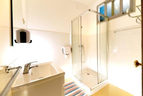 ein Bad mit einer Dusche und einem Waschbecken in der Unterkunft Eskama guest house in Esposende