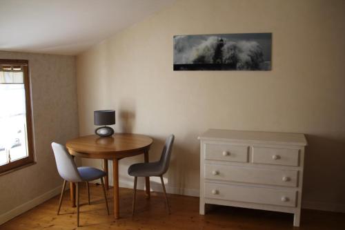 une chambre avec une table, des chaises et une commode dans l'établissement Rêve Fontaine, à Joinville