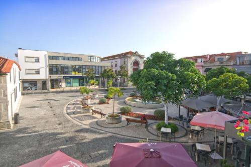 a courtyard with tables and umbrellas in a city at Eskama guest house in Esposende