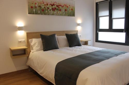 a bedroom with a large bed with red flowers on the wall at Apartamentos La Luna in La Solana