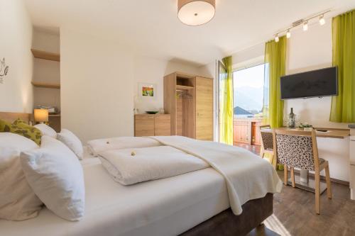 a bedroom with a bed and a desk with a television at Landhaus Tripolt in Radstadt