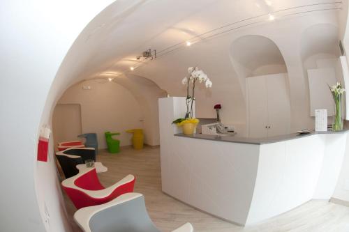 una stanza con sedie rosse e bianche e un bancone di Hotel Pinamonte a Costermano