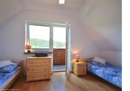 a bedroom with two beds and a window at Domek u Bigola in Polańczyk