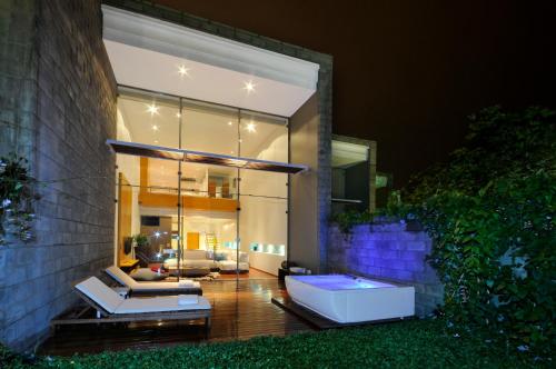 a house with two chairs and a couch on a patio at AcquaSanta Lofts Hotel in Cali