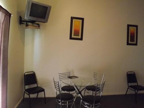 a dining room table with a television on it at Bay Road Motels in Haast