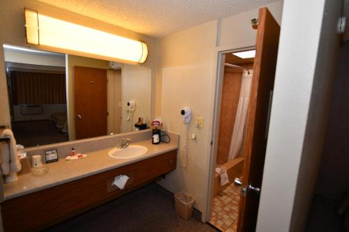 a bathroom with a sink and a large mirror at Costa Mesa Inn - Newport Beach Area in Costa Mesa