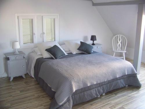 a bedroom with a large bed with two tables and a chair at C' 1 comble in Bischwihr