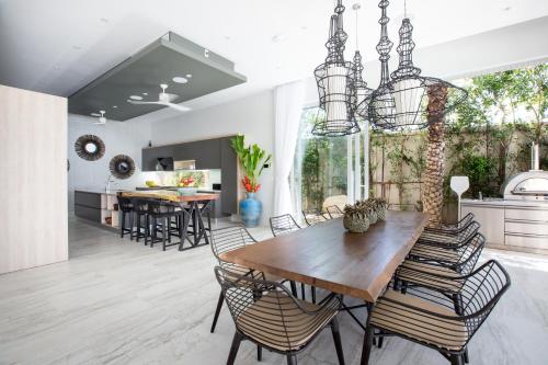 een keuken en eetkamer met een houten tafel en stoelen bij Moonstone - Samui's Premier Private Villa in Bangrak Beach