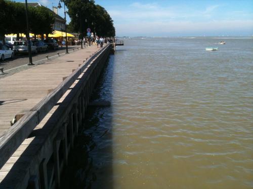 a pier next to a body of water with a boat at Hotel du Port et des Bains in Saint-Valery-sur-Somme