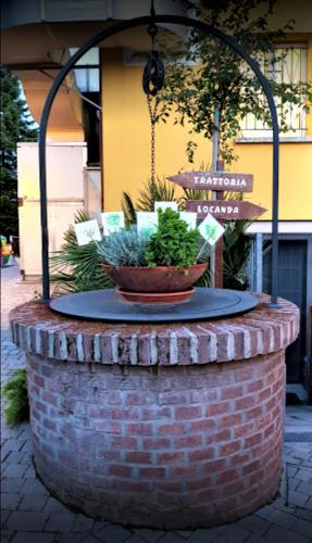 a brick fountain with two plants on top of it at Osteria da Cesare e Locanda in Castel San Pietro Terme