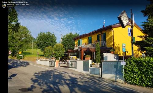 a yellow house on the side of a road at Osteria da Cesare e Locanda in Castel San Pietro Terme