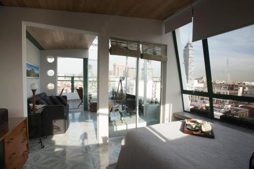 a bedroom with a bed and a view of a city at Dúplex/terraza privada en corazón Centro Histórico in Mexico City