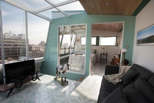 a living room with a couch and a television at Dúplex/terraza privada en corazón Centro Histórico in Mexico City