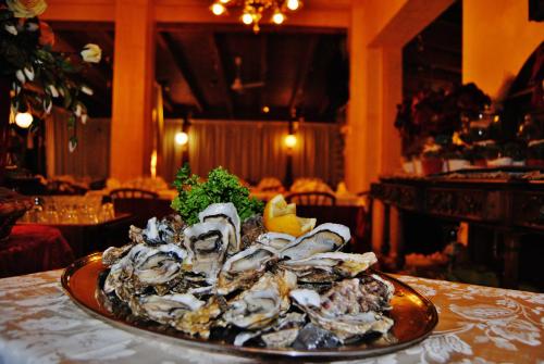 a plate of oysters on a table in a restaurant at Hotel Italia in Lerici