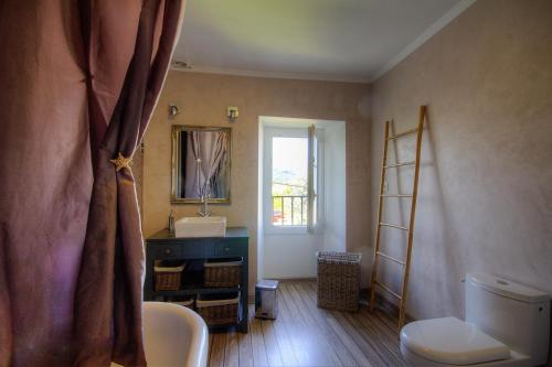 une salle de bain avec un lavabo, des toilettes et un miroir dans l'établissement La Casalamadonna, à Santa-Lucia-di-Moriani