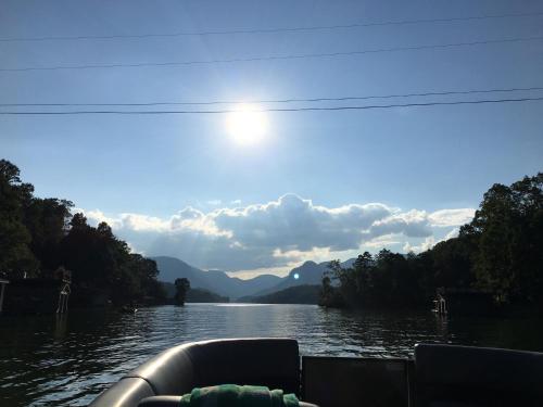 a boat on a river with the sun in the sky at Grafton Lodge in Lake Lure