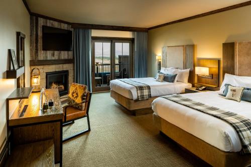 um quarto de hotel com duas camas e uma lareira em Sage Lodge em Pray