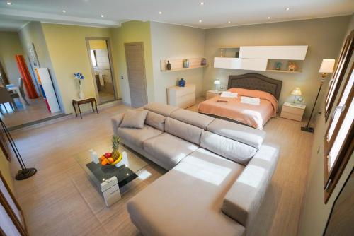 uma sala de estar com um sofá e uma cama em Luxury Home Garden Apartment Bosa Marina em Bosa Marina