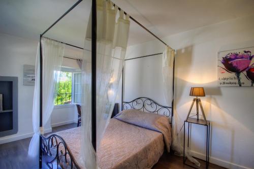 une chambre avec un lit à baldaquin et une fenêtre dans l'établissement La Casalamadonna, à Santa-Lucia-di-Moriani