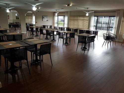 een kamer met tafels en stoelen in een gebouw bij Panorama Hotel in Governador Valadares