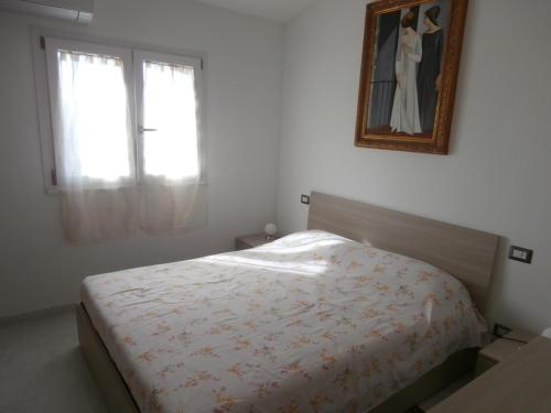 - une chambre avec un lit et une photo sur le mur dans l'établissement Bilo Francesca e Massimo, à Castelnuovo Magra