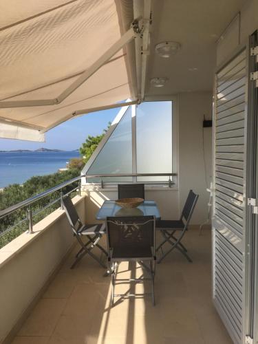 a balcony with a table and chairs and a view of the ocean at Galeb in Vodice