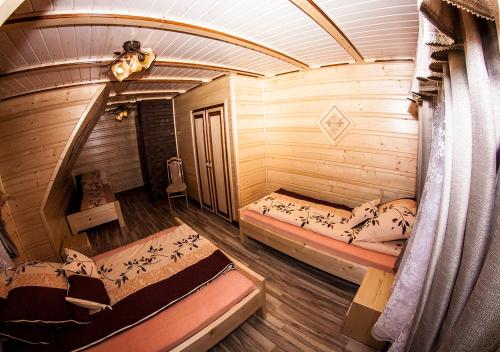 a room with two beds in a log cabin at Chatka Pod Laskiem - Domki w górach in Soblówka