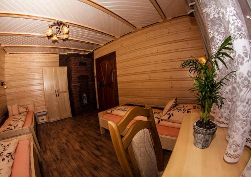 a room with two beds and a table and a plant at Chatka Pod Laskiem - Domki w górach in Soblówka