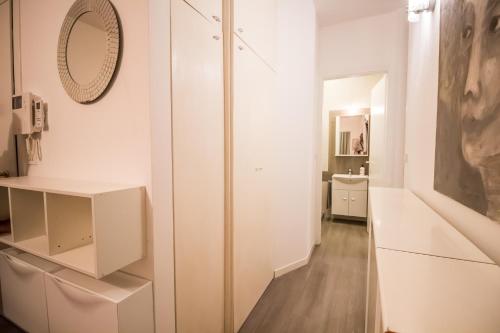 アルタヴィッラ・ヴィチェンティーナにあるCasa Claraの白いキャビネットと壁掛け鏡が備わる客室です。